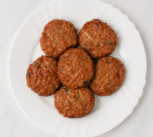 Burger Patties on a white plate, frozen ready-to-cook pork burger patty.