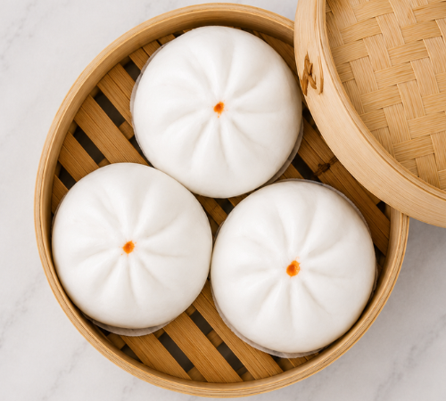 Mini Bola-bola Siopao served in an open bamboo steamer basket.