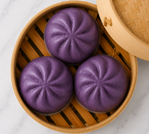Mini Ube Siopao served in an open bamboo steamer basket.